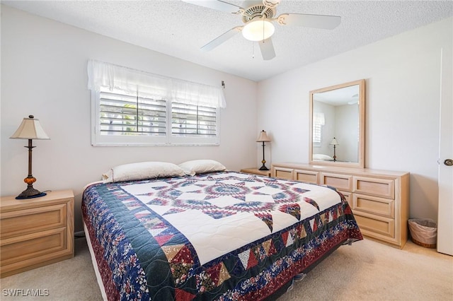 carpeted bedroom featuring ceiling fan and a textured ceiling