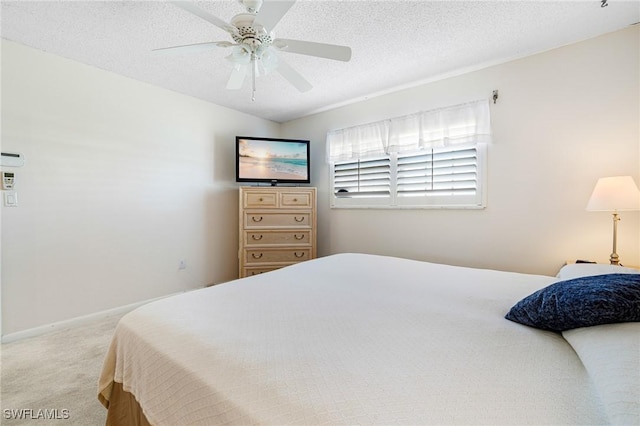 carpeted bedroom with ceiling fan and a textured ceiling