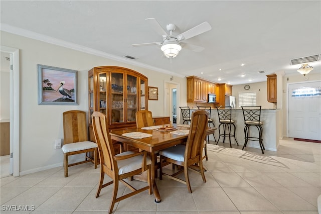 dining room featuring light tile patterned floors, ornamental molding, and ceiling fan