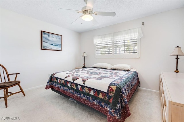 carpeted bedroom with ceiling fan and a textured ceiling