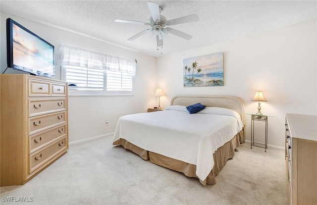 bedroom featuring ceiling fan, a textured ceiling, and light carpet