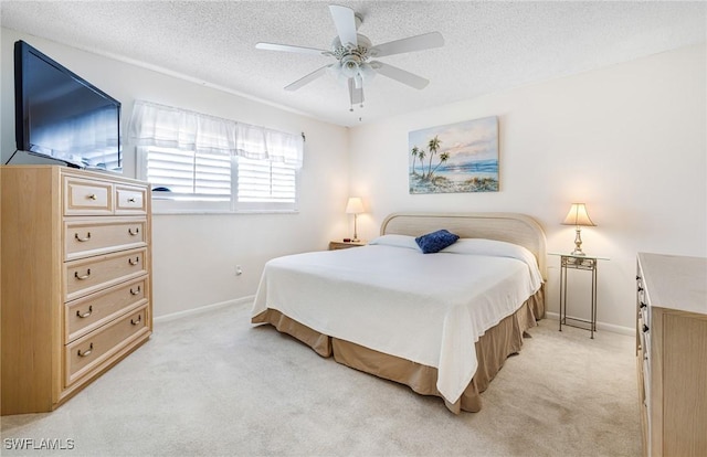 bedroom with a textured ceiling, ceiling fan, and light colored carpet