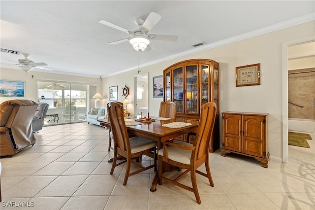 tiled dining area featuring ceiling fan and ornamental molding