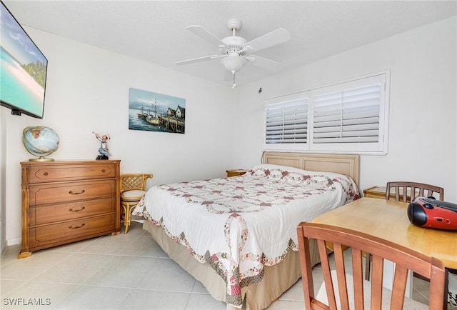 bedroom featuring ceiling fan, a textured ceiling, and light tile patterned floors