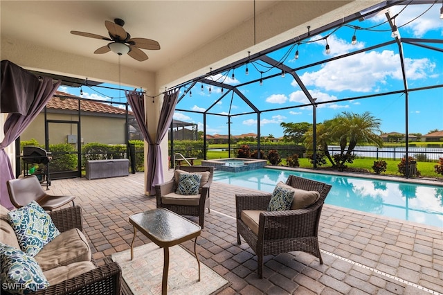 view of swimming pool with an in ground hot tub, ceiling fan, glass enclosure, a patio area, and a grill