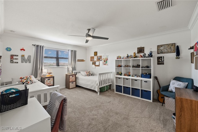 carpeted bedroom with ceiling fan and ornamental molding