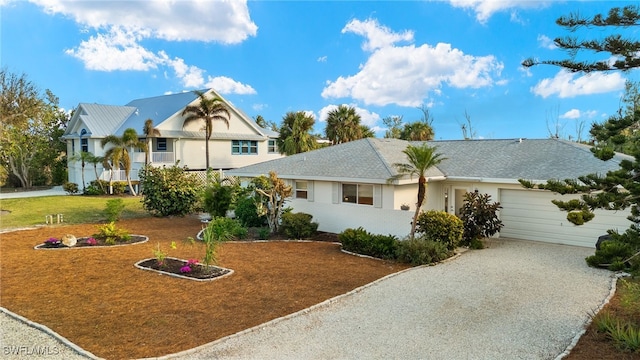 ranch-style house with an attached garage, gravel driveway, and a front yard