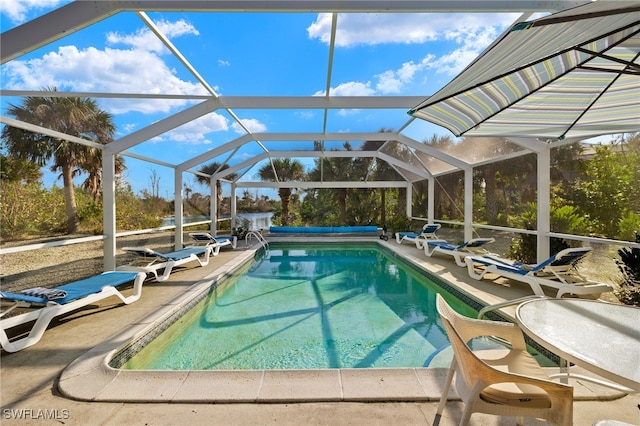 view of pool with glass enclosure, a covered pool, and a patio