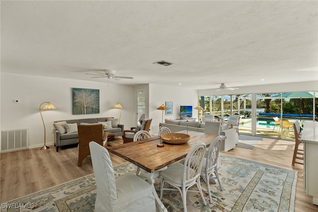 dining room featuring ceiling fan, light hardwood / wood-style floors, and a textured ceiling