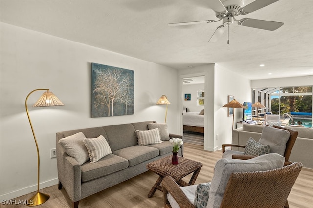 living room with light hardwood / wood-style floors and ceiling fan