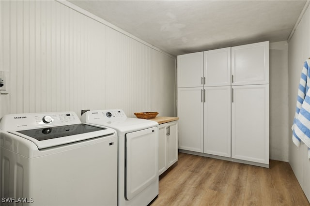 laundry room with cabinets, independent washer and dryer, and light hardwood / wood-style flooring