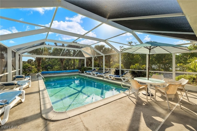 view of swimming pool featuring glass enclosure and a patio