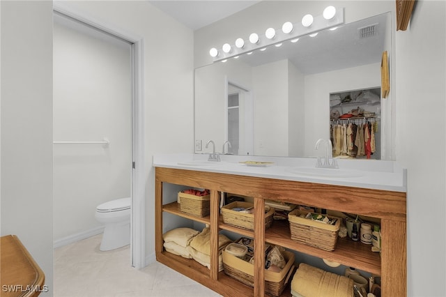 bathroom featuring tile patterned flooring, vanity, and toilet