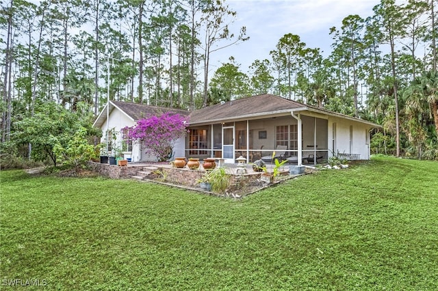 view of front of property featuring a sunroom and a front lawn