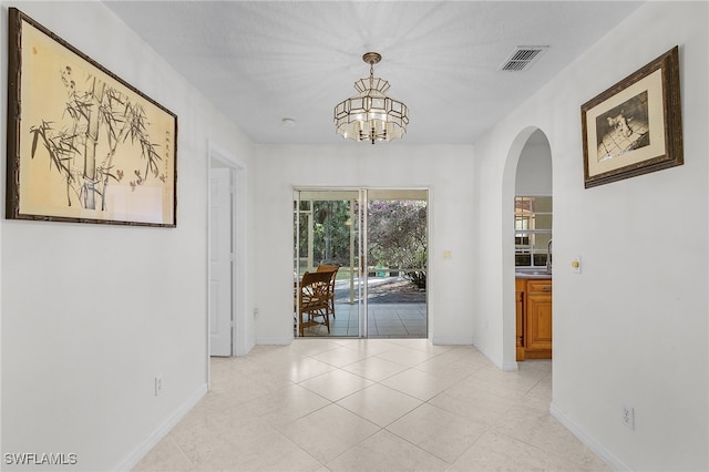 interior space with a chandelier and light tile patterned floors