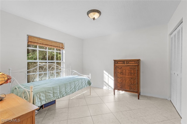 tiled bedroom with a closet