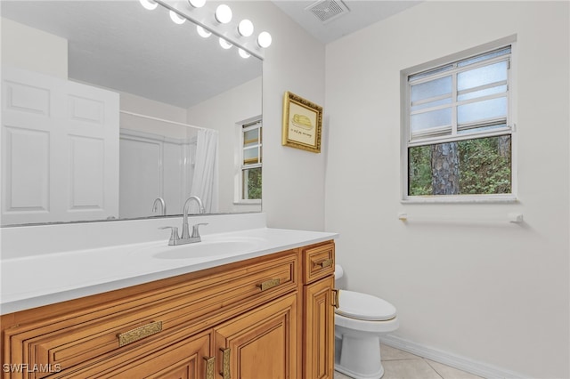 bathroom with tile patterned floors, walk in shower, vanity, and toilet