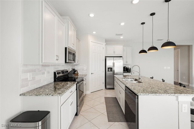 kitchen with pendant lighting, sink, white cabinets, a kitchen island with sink, and stainless steel appliances