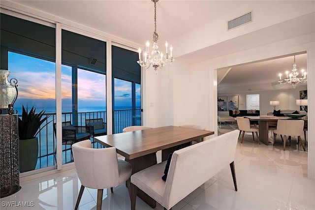 dining area featuring visible vents, a water view, a chandelier, and floor to ceiling windows