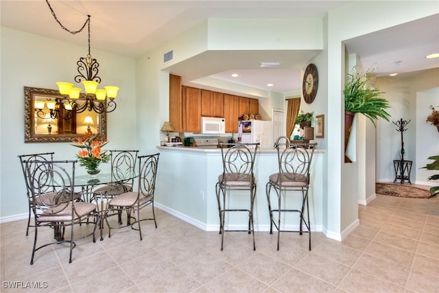 kitchen featuring white appliances, decorative light fixtures, light tile patterned flooring, kitchen peninsula, and a chandelier