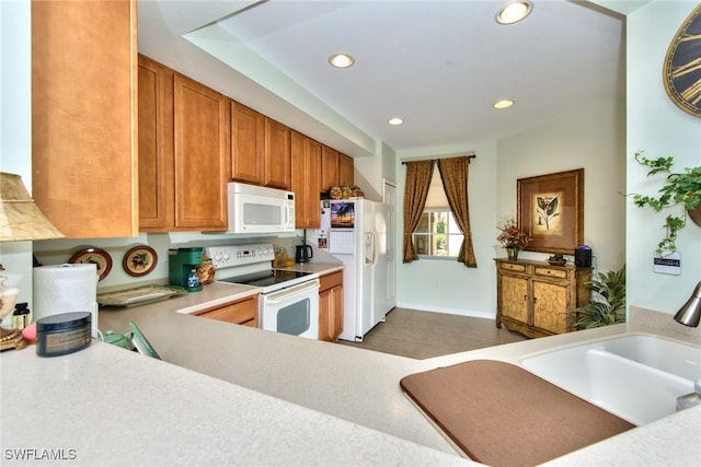 kitchen featuring white appliances, dark tile patterned floors, and sink