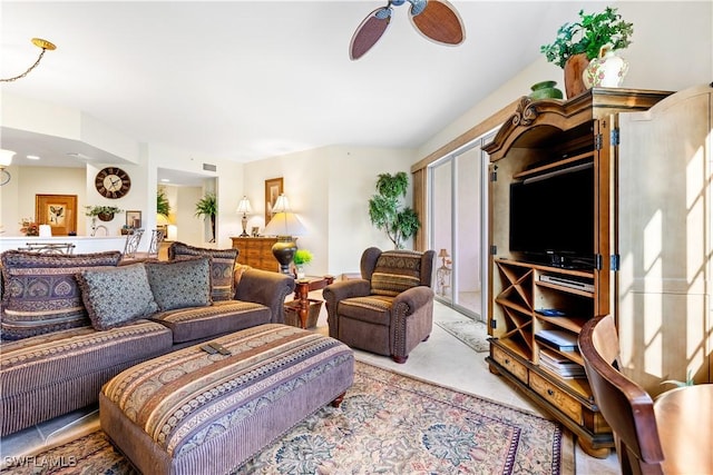 living area with light tile patterned floors and a ceiling fan