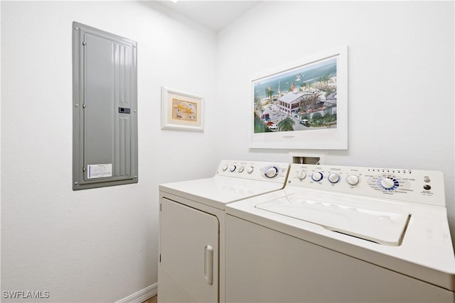 washroom featuring washing machine and dryer, laundry area, electric panel, and baseboards