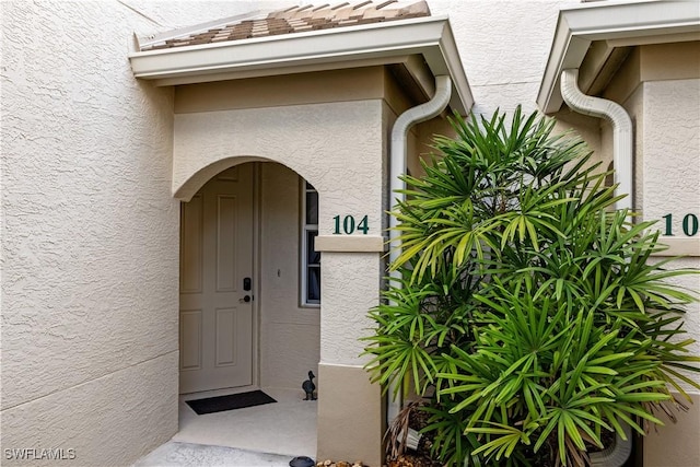 view of exterior entry featuring stucco siding