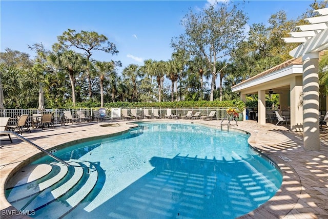 community pool featuring fence, a ceiling fan, and a patio