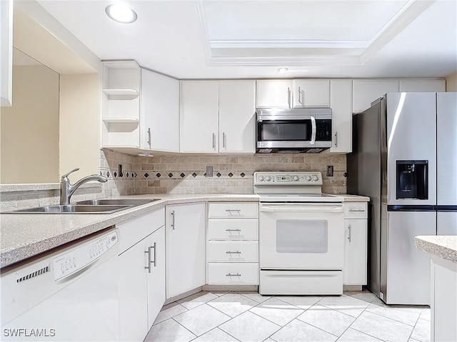 kitchen with sink, white cabinets, a raised ceiling, light tile patterned floors, and appliances with stainless steel finishes