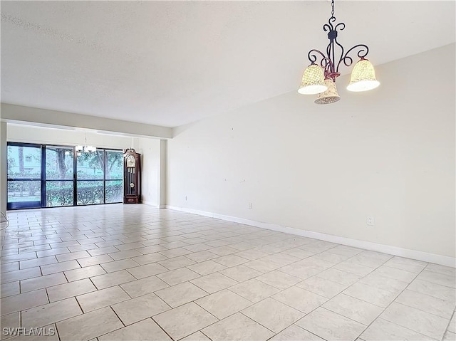 spare room with a notable chandelier and light tile patterned floors