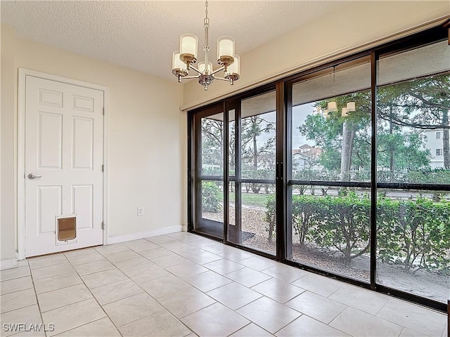 entryway featuring a notable chandelier, a textured ceiling, and light tile patterned floors