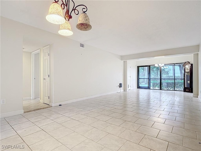 tiled empty room with a notable chandelier