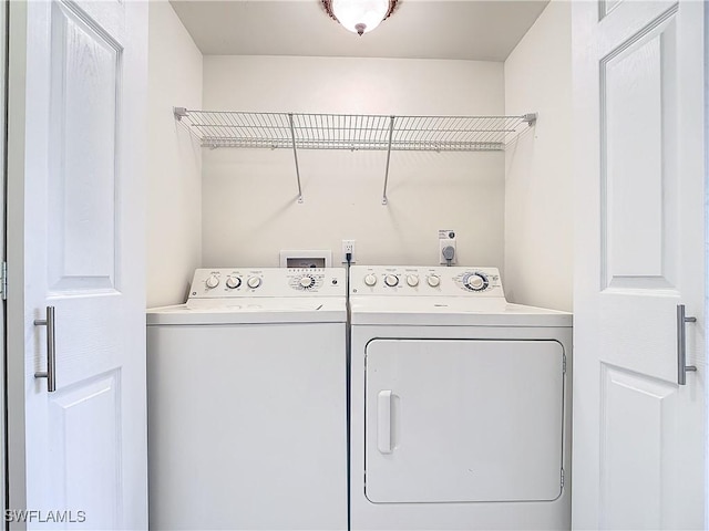 clothes washing area with separate washer and dryer