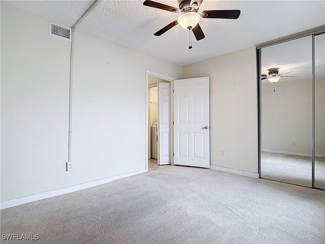 unfurnished bedroom with a textured ceiling, ceiling fan, and light carpet