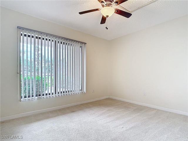 carpeted spare room featuring a textured ceiling and ceiling fan