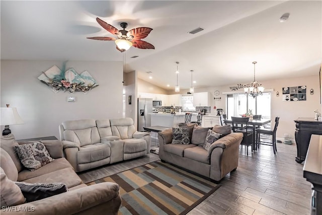 living room featuring vaulted ceiling, dark hardwood / wood-style floors, and ceiling fan with notable chandelier