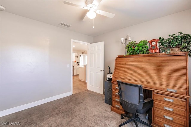 carpeted office space with ceiling fan