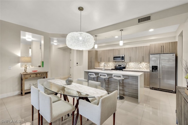 tiled dining room featuring sink and a tray ceiling