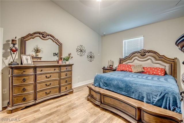 bedroom featuring light wood-type flooring and vaulted ceiling