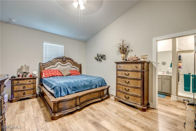 bedroom featuring ceiling fan, lofted ceiling, connected bathroom, and light hardwood / wood-style flooring