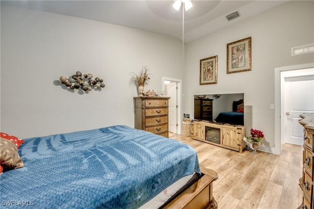 bedroom featuring ceiling fan, light hardwood / wood-style floors, and connected bathroom