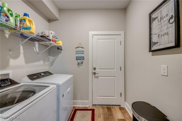 clothes washing area with light wood-type flooring and washer and clothes dryer