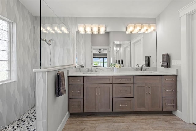 bathroom featuring a tile shower and vanity