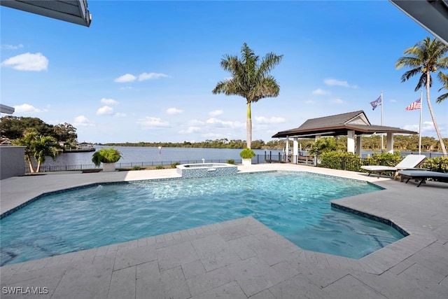 view of pool featuring an in ground hot tub, a patio, and a water view