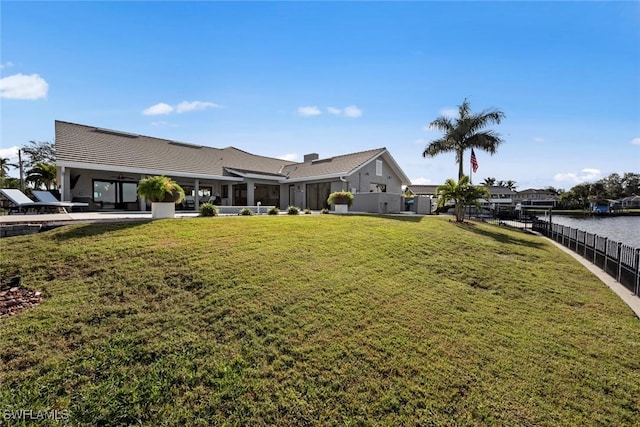 exterior space with a lawn, a patio area, and a water view