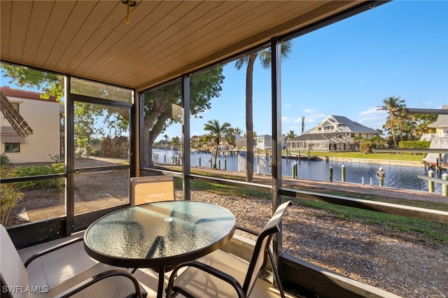 sunroom / solarium featuring a water view and wood ceiling