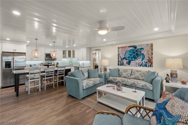 living room featuring ceiling fan, sink, wooden ceiling, and hardwood / wood-style flooring