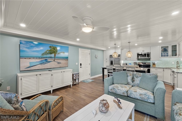 living room featuring dark hardwood / wood-style floors, ceiling fan, and sink