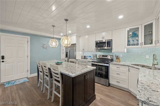 kitchen with white cabinetry, sink, tasteful backsplash, light hardwood / wood-style floors, and appliances with stainless steel finishes